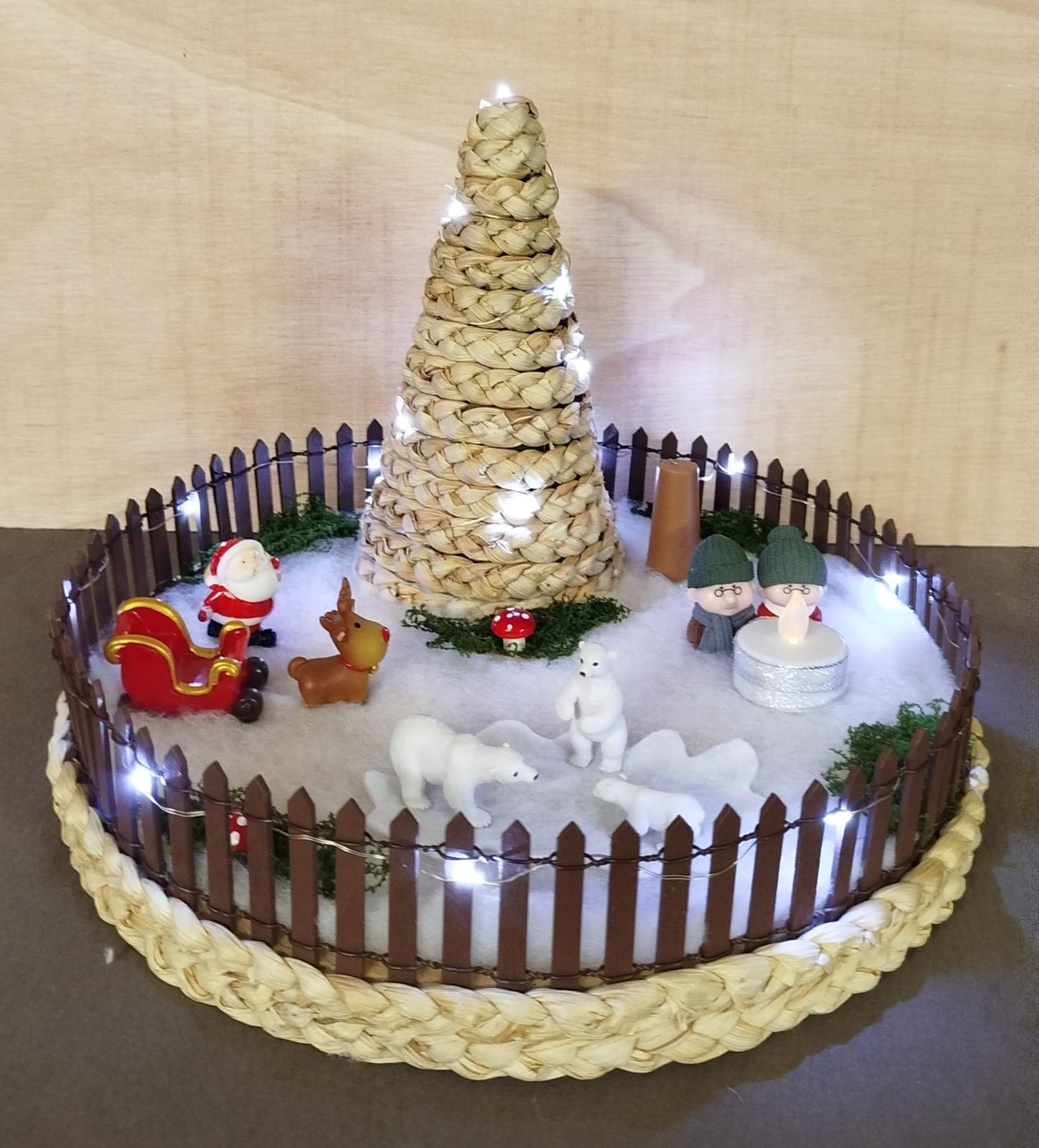 Aldeia de Natal montada dentro de um cesto, com pinheiro de corda iluminado